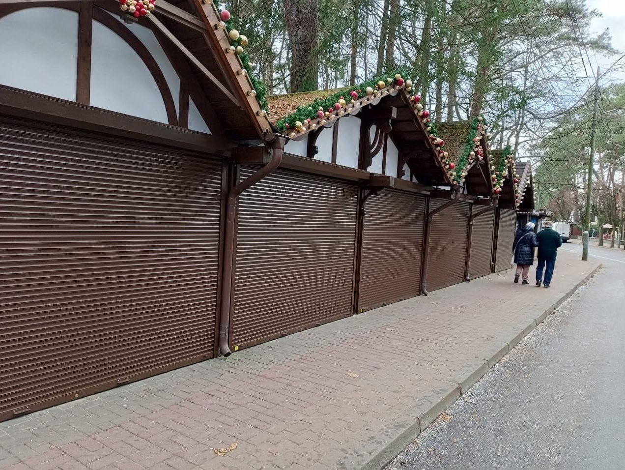Коричневые рольставни на торговых павильонах ярмарки в парке